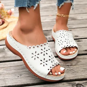 Macro view of white ladies platform sandals with intricate floral cut-out details.