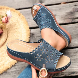 Close-up detail of blue laser-cut floral wedge sandals with platform soles for summer