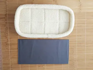Close-up of white sherpa fleece pet pad and dark grey base board insert for carrier