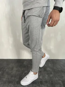 Vista laterale dettagliata dei pantaloni sportivi grigi slim fit da uomo su modello