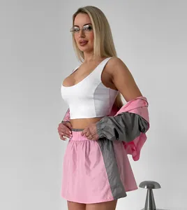 High quality detail view of women's fashion pink and grey color-block jacket and mini skirt set
