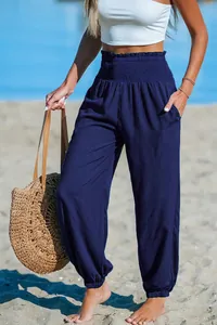 Detail of navy blue beach harem pants with high smocked waist and pockets on beach
