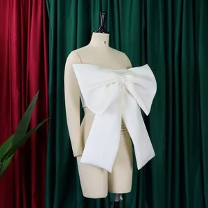 Vista dettagliata di un top a fascia bianco a forma di fiocco oversize su un manichino da sarta.