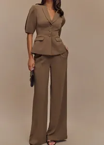 Détail d'un ensemble élégant blazer à basque manches courtes et pantalon large.