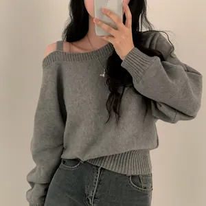 Vista dettagliata di un maglione a maglia grigio con spalle scoperte e vestibilità relax