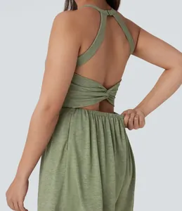 Detail view of the backless twist design and elastic waist on a green jumpsuit