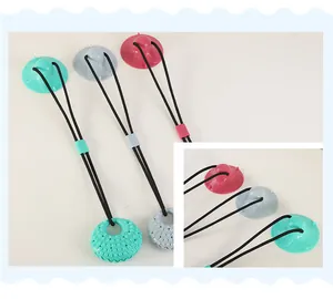 Detail showing three colorful suction cup dog pull toys with textured molar balls