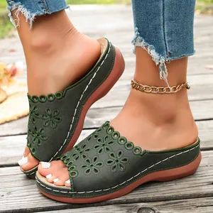 Close-up of women's peep-toe wedge sandals with a dark green hollow floral design