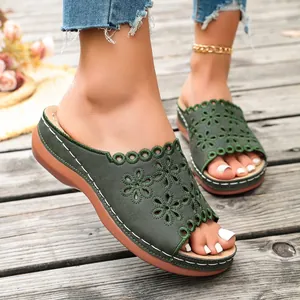 Detailed view of women's dark green platform sandals with intricate floral embroidery.