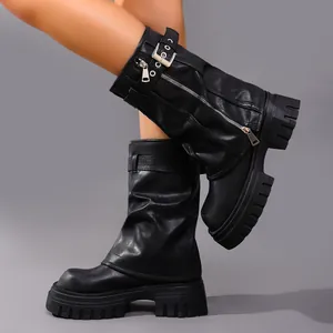 Detail of black platform biker boots with side zippers and buckles in leather finish.