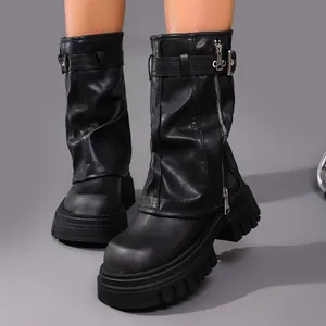 Close-up of black leather platform boots featuring square toe and slouchy shaft design