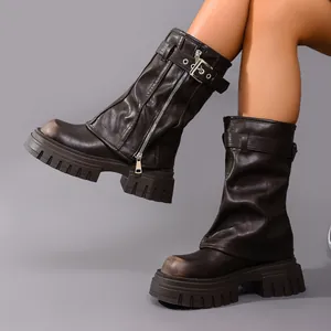 Detailed view of brown leather platform motorcycle boots with buckle and zipper accents