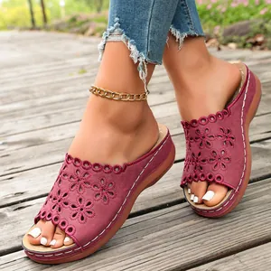 Detail of women's burgundy platform slides with intricate floral cut-out patterns.