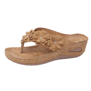 Detailansicht der braunen Damen Keilsandalen mit 3D Blumenverzierung von der Seite