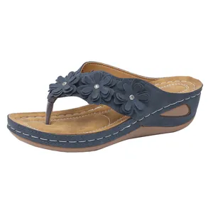 Detailansicht von marineblauen Keil-Flip-Flops mit Blumen und Strasssteinen