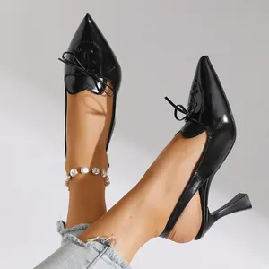 Detailed view of black pointed-toe stiletto pumps with elegant bow and lace-up details.