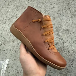 Vue détaillée latérale de bottines en cuir marron de style britannique à lacets.