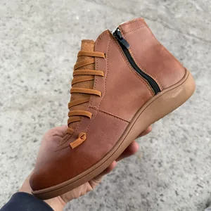 Vue détaillée d'une bottine en cuir marron avec fermeture éclair latérale et lacets