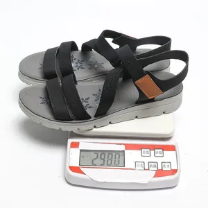 Black and grey sport sandals being weighed on a white digital scale showing 298 grams