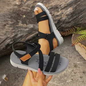 Detail view of lightweight sport sandals with black elastic straps and thick grey soles
