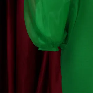 Close-up detail showing the green mesh puff sleeve texture on women's pencil dress