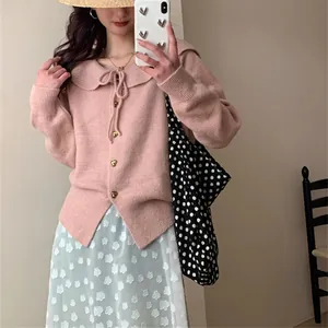 Detailed view of sweet pink knit cardigan featuring Peter Pan collar and heart-shaped buttons