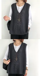 Vista dettagliata del gilet in maglia grigio scuro con scollo a V e motivi traforati