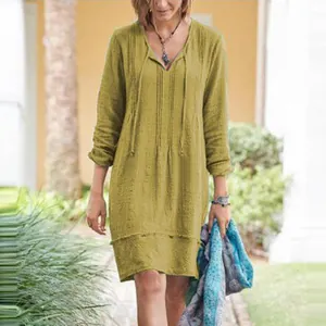 Casual mustard yellow V-neck lace-up midi dress with long sleeves shown on model outdoors