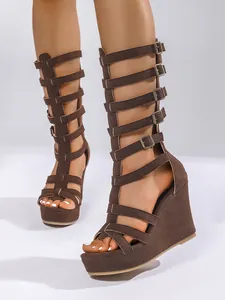 Detailansicht brauner Wildleder-Gladiatoren-Keilsandalen mit hohem Schaft und Schnallen.