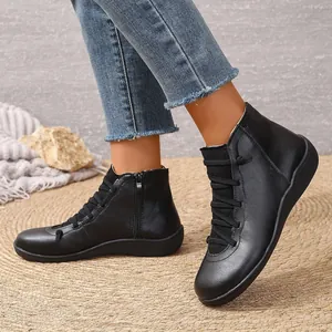 Gros plan de bottines élégantes en cuir noir avec fermeture éclair latérale pour femmes.