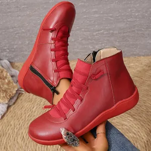 Vue détaillée de bottines élégantes en cuir rouge avec fermeture éclair et lacets