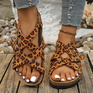 Detailopname van sandalen met luipaardprint, kruisbanden, kurken voetbed en metalen gespen