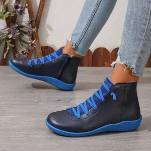 Gros plan de bottines en cuir bleu marine avec lacets et semelles bleu vif