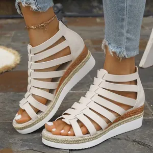 Detail view of white Roman platform sandals with braided wedge sole and rear zipper.