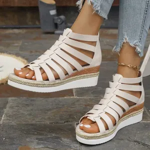 Detail view of off-white gladiator wedge sandals featuring cross straps and back zipper