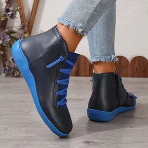 Vue latérale de bottines bleu marine élégantes avec semelles et lacets bleu vif