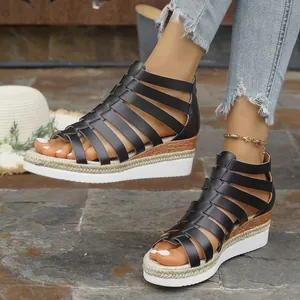 Close-up view of comfortable black strappy Roman platform sandals worn by a model outdoors