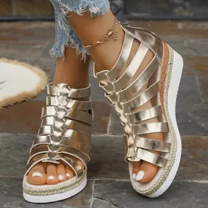 Detail view of stylish gold strappy Roman wedge sandals with a back zipper closure