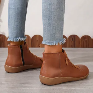 Vue latérale détaillée de bottines en cuir marron avec fermeture éclair et lacets élégants