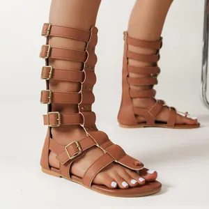 Detailansicht brauner kniehoher Gladiatoren-Sandalen mit mehreren Schnallenriemen am Fuß