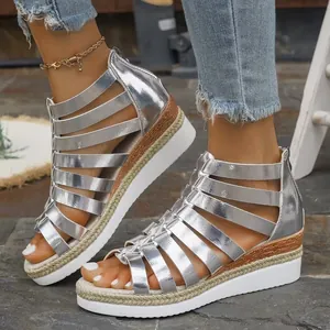 Close-up detailed view of silver metallic gladiator wedge sandals with back zipper.