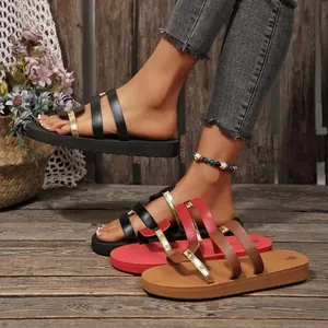 Detailed view of women's flat sandals with metallic gold straps in black red and brown