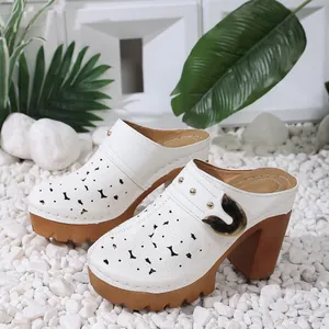 Vue latérale de mules blanches à plateforme avec motifs floraux découpés au laser
