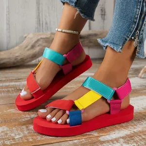 Détail de sandales à plateforme colorées avec brides velcro multicolores au sol