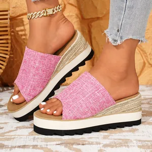 Mules compensées en tissu rose avec plateforme épaisse et design à bride unique.