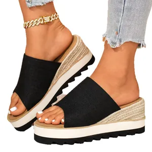 Sandales compensées noires élégantes avec détail espadrille tressé et semelle blanche.