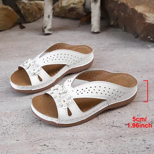 Détail montrant le talon compensé de 5 cm des sandales blanches à fleurs