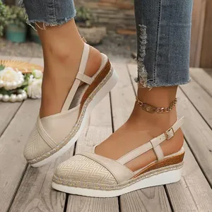Primer plano de sandalias de cuña beige con punta cerrada, suela de cáñamo y correa