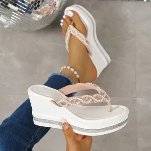 Vista detallada de chanclas blancas con cuña y plataforma con elegantes correas de perlas