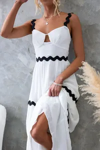 Vue détaillée d'une robe d'été blanche avec bordure ondulée noire et découpe.
